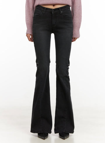 LEWKIN Belle Slim Fit Flared Jeans CD410 in black, front view on model, low-waist washed denim with slim thigh and wide flared hem, styled with pink knit sweater and black heels.