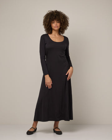 Model wearing Valerie Maxi Dress in Black. Valerie Maxi Dress is a merino wool long sleeve, scoop neck, maxi swing dress available in sizes XS-XXL.