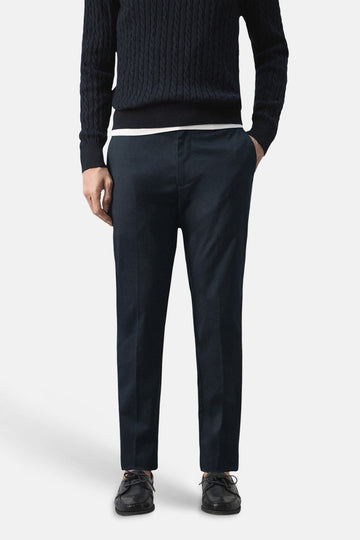 Pantalon chino bleu de MANGO, vu de dos, avec un motif uni et un pull bleu foncé.
