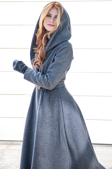 Woman wearing a gray Princess Winter Coat with a tie waist and slouchy hood standing outdoors
