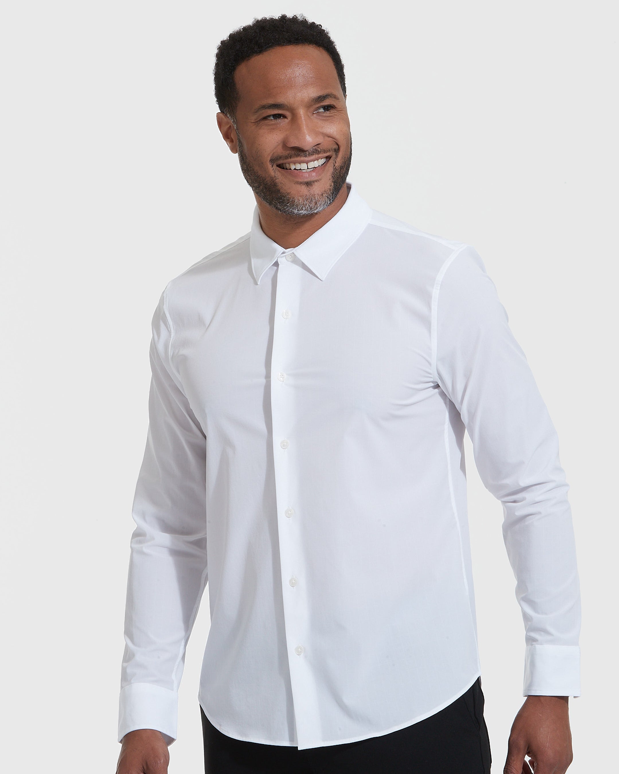 White Lightweight Dress Shirt worn by smiling male model against gray backdrop.