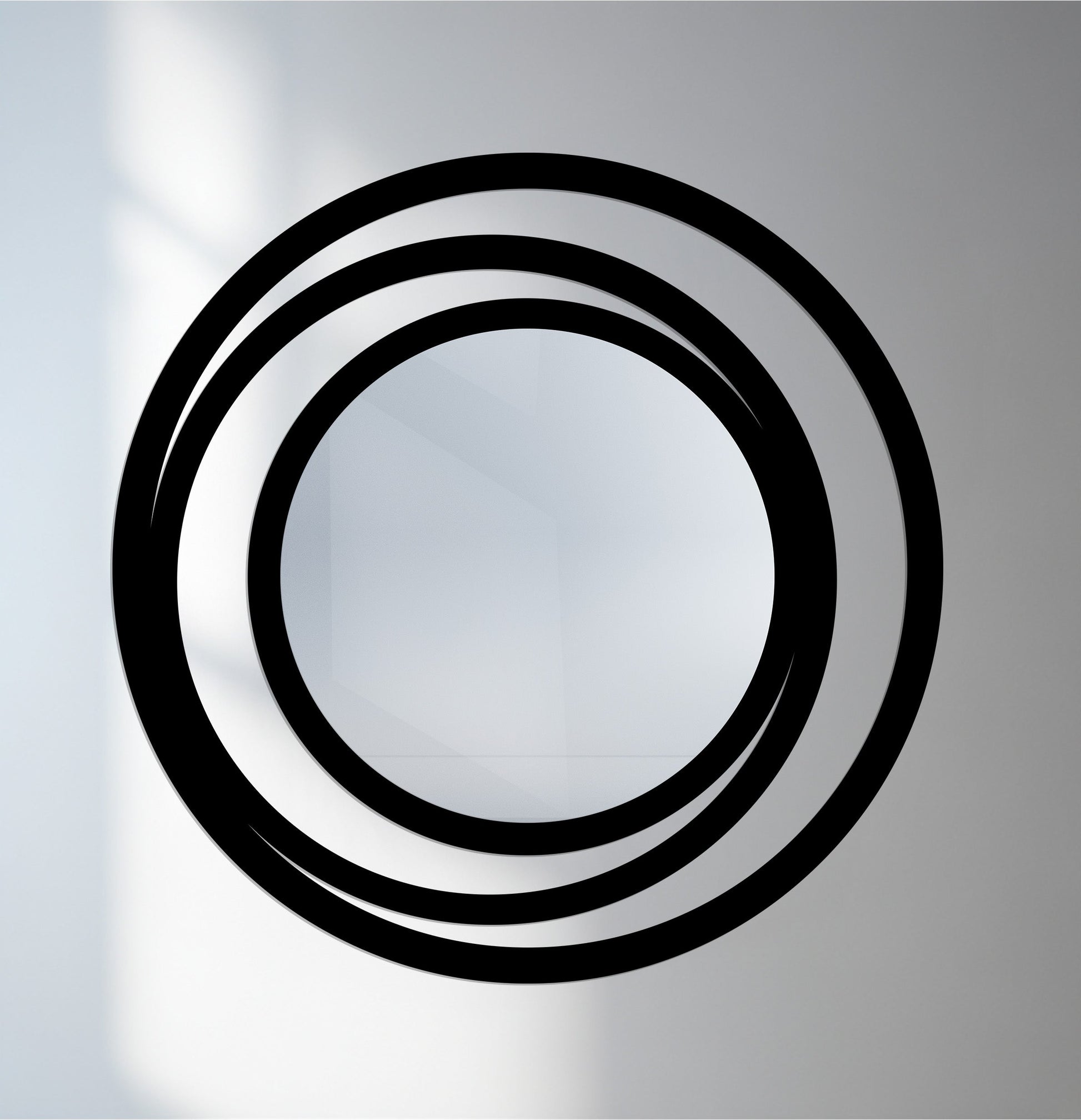 Foreground detail reveals a modern round bathroom mirror with a triple circle frame, showcasing its minimalist metal design.