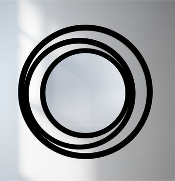 Foreground detail reveals a modern round bathroom mirror with a triple circle frame, showcasing its minimalist metal design.