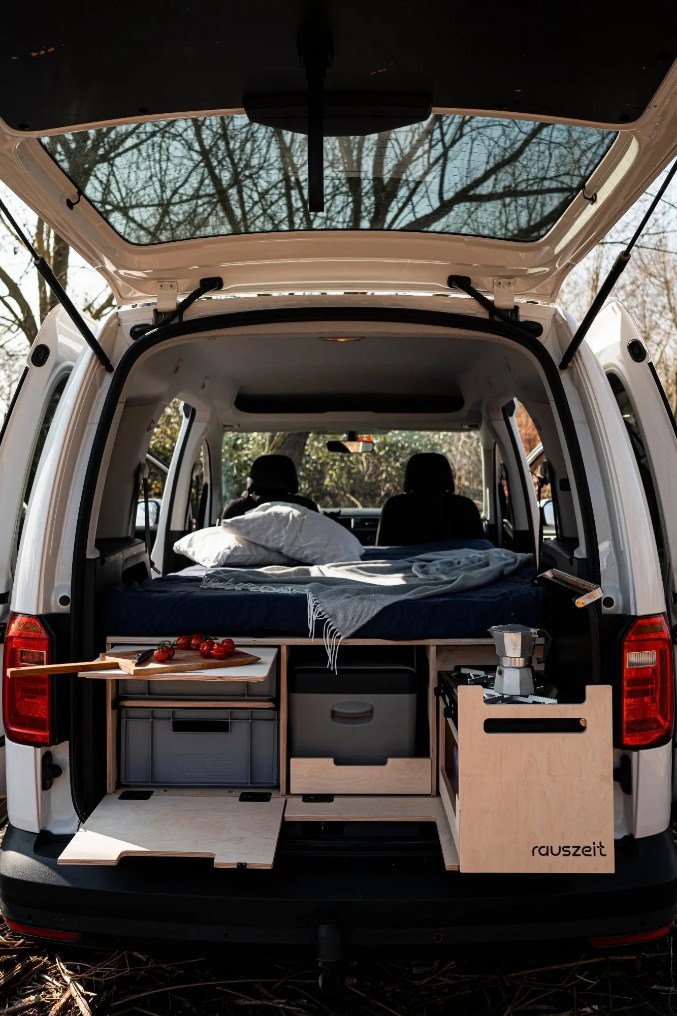 Campingbox mit ausgezogenem Schiebebett und Kochmodul im Hochdachkombi