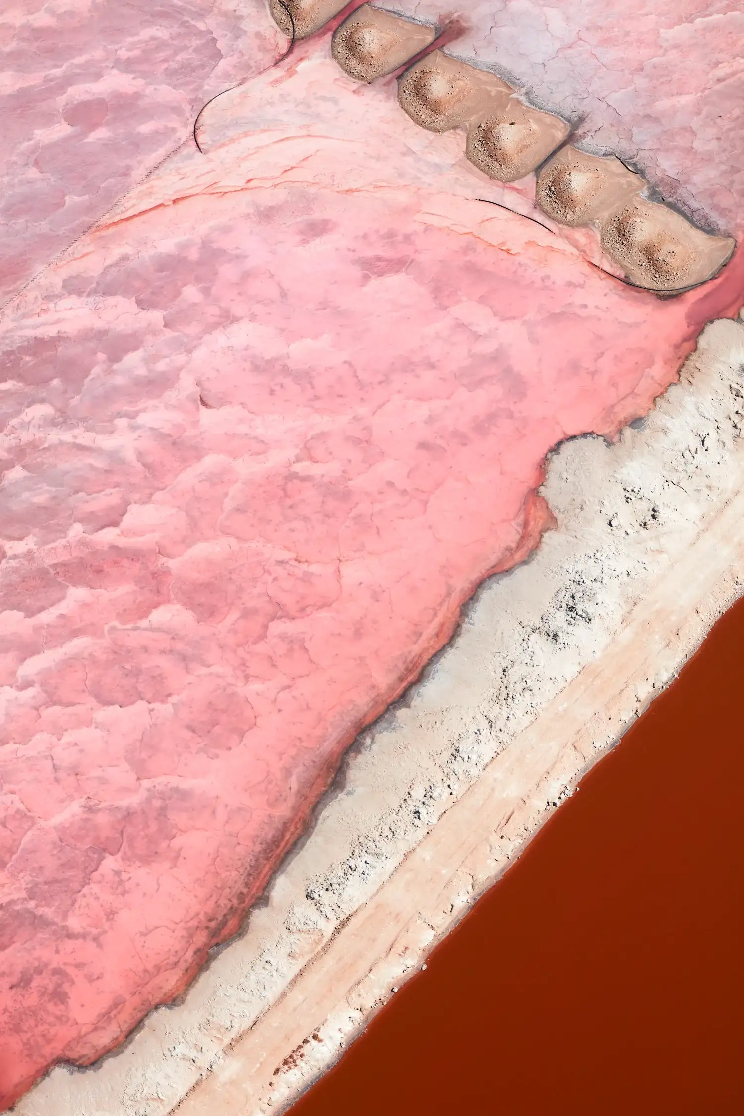 Displace aerial abstraction of Hutt Lagoon, WA. Pink salt flats and ferric red water contrast on framed print.