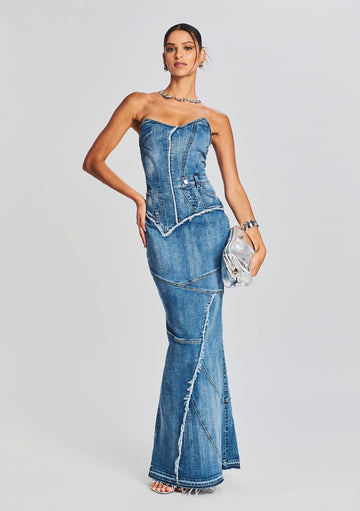 Strapless denim dress with a fitted corset bodice and paneled long skirt with frayed seams.