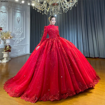 Full front view of a model showcasing a stunning full coverage wine red Muslim wedding dress featuring a high neckline, long sleeves, and a voluminous ball gown skirt with heavy hand beading.
