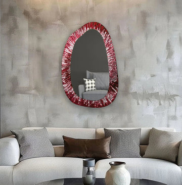 Realistic detail shows the red abstract entryway wall mirror with its irregular frame reflecting a nearby chair, enhancing its role as a distinctive bathroom mirror.