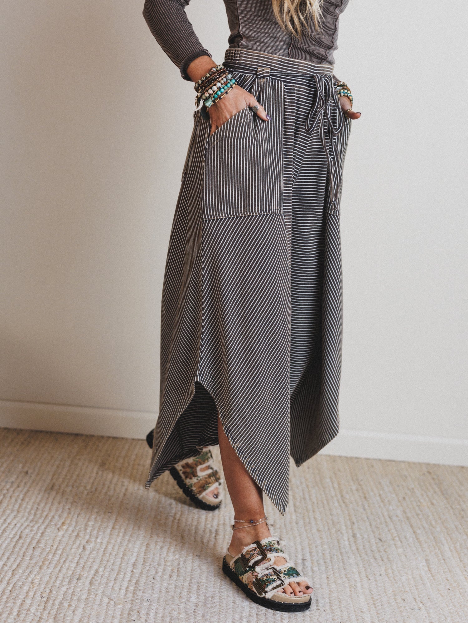 Person wearing a long, patterned pants with a neutral background