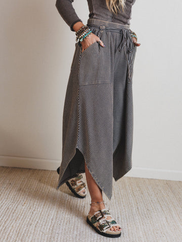 Person wearing a long, patterned pants with a neutral background
