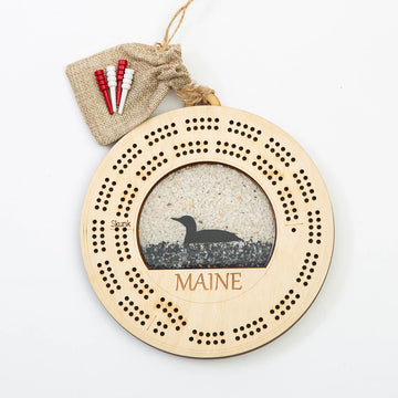 Maine Shellware Cribbage board featuring a Maine loon design with crushed shell inlay on polished wood surface.