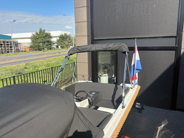 Achteraanzicht van Marinaut 485 sloep met Nederlandse vlag en cabrioletkap, perfect voor recreatief varen.