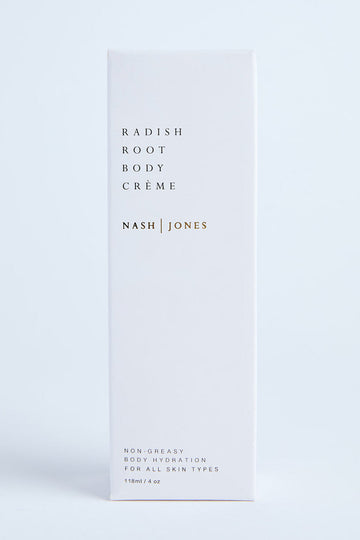 A white bottle of Nash & Jones Radiant Body Crème standing against a light background, with minimalistic design and a faint citrus/grapefruit scent indicated on the bottle.