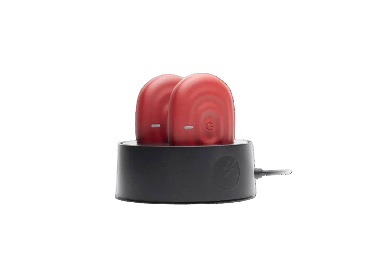 Red wireless TEN device in a black charging case on a white background