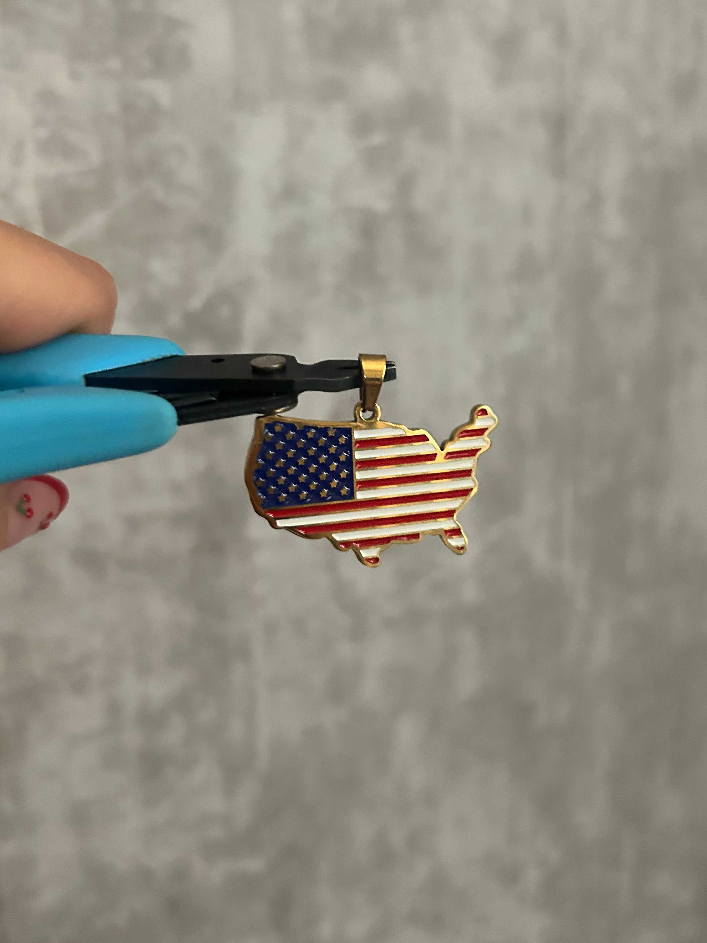 America Flag necklace being held by pliers