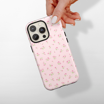 Hand holding Cocopup London Tough Phone Case in pink with a green and pink ditsy floral pattern.