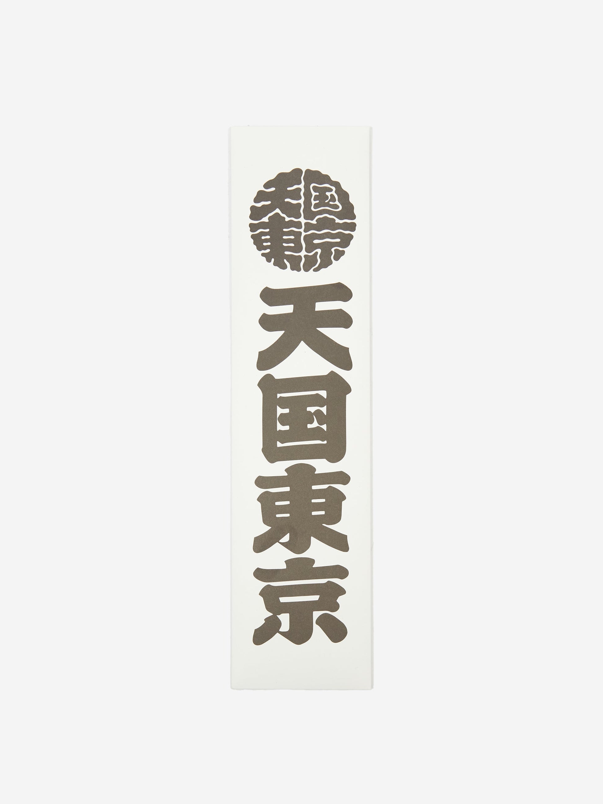 The Wacko Maria x Kuumba Incense Stick - Paradise features a white vertical plaque with bold black Japanese kanji in a column, topped by a circular emblem in Wacko Maria’s signature style, followed by three large kanji symbols.