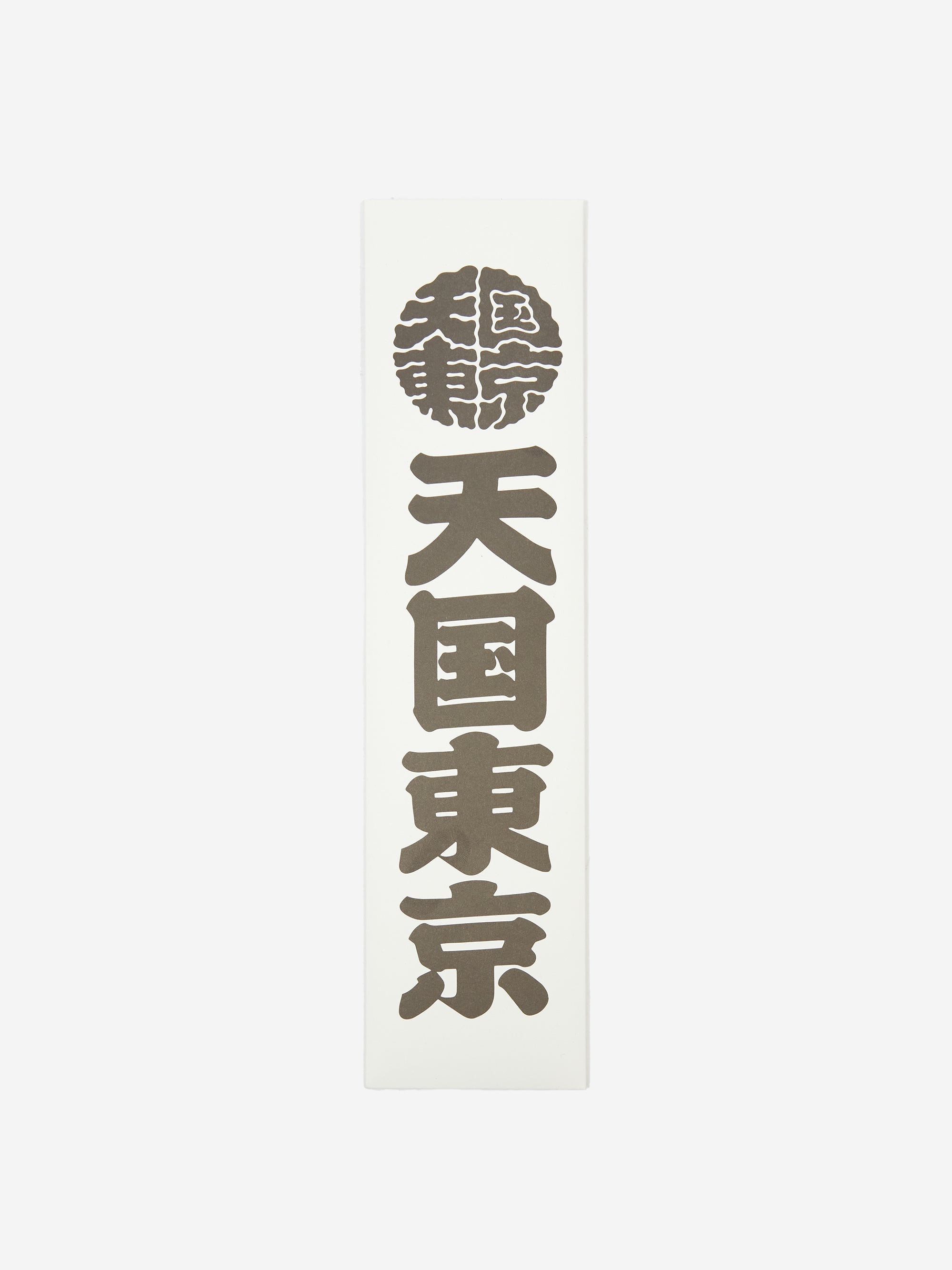 The Wacko Maria x Kuumba Incense Stick - Paradise features a white vertical plaque with bold black Japanese kanji in a column, topped by a circular emblem in Wacko Maria’s signature style, followed by three large kanji symbols.