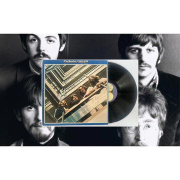 Vinyl record with cover art overlayed on a black-and-white photo of four men.