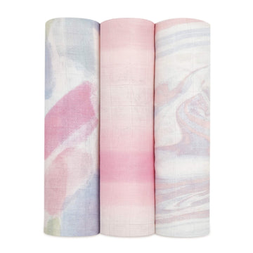 Three aden + anais silky soft muslin swaddles in the Florentine set, rolled to show pastel abstract prints.