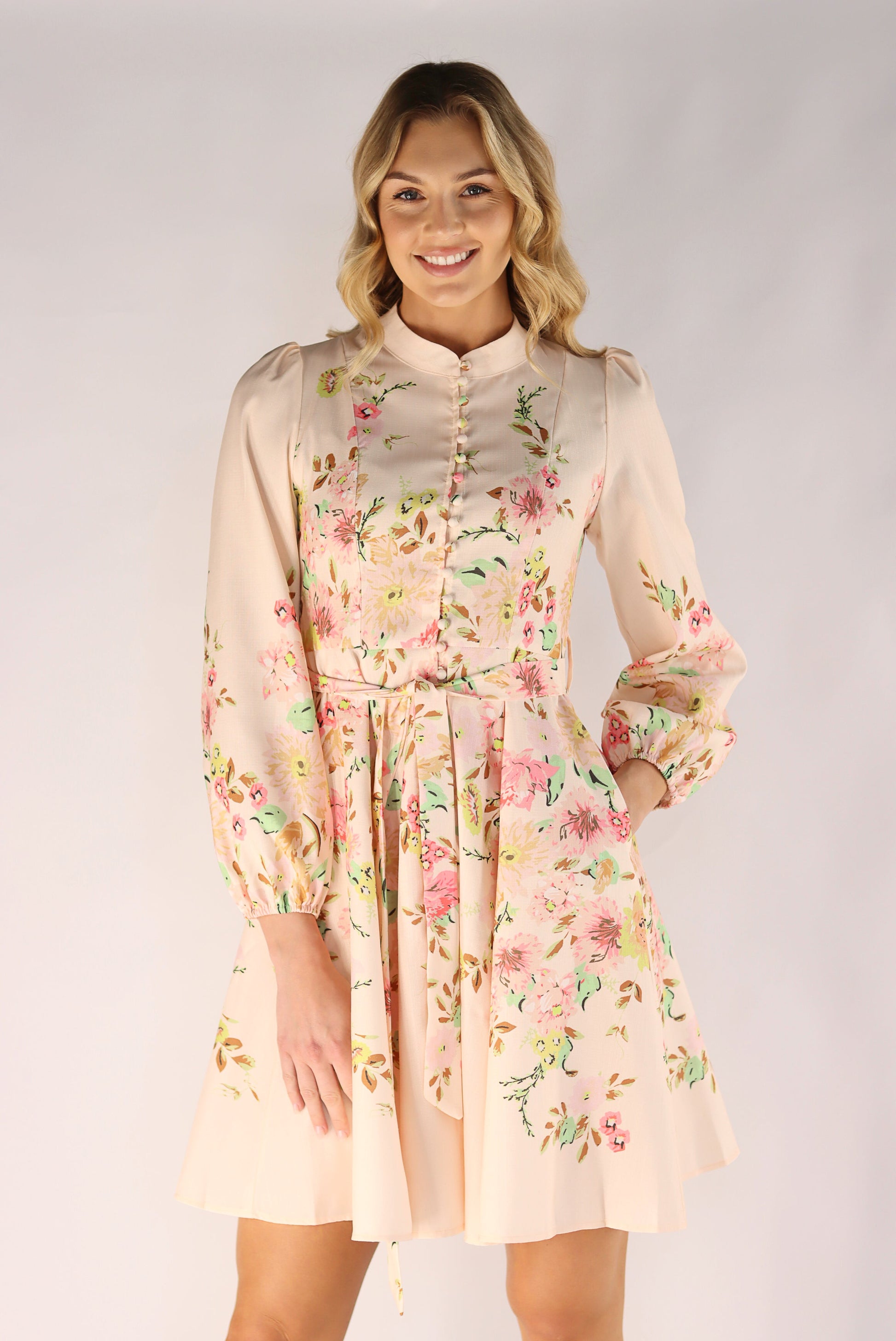 Woman wearing a floral dress against a plain background