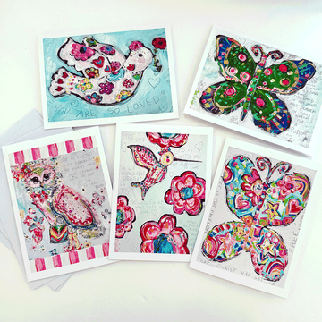 A collection of five colorful blank notecards with various designs, including floral patterns and an owl, displayed with their respective envelopes.